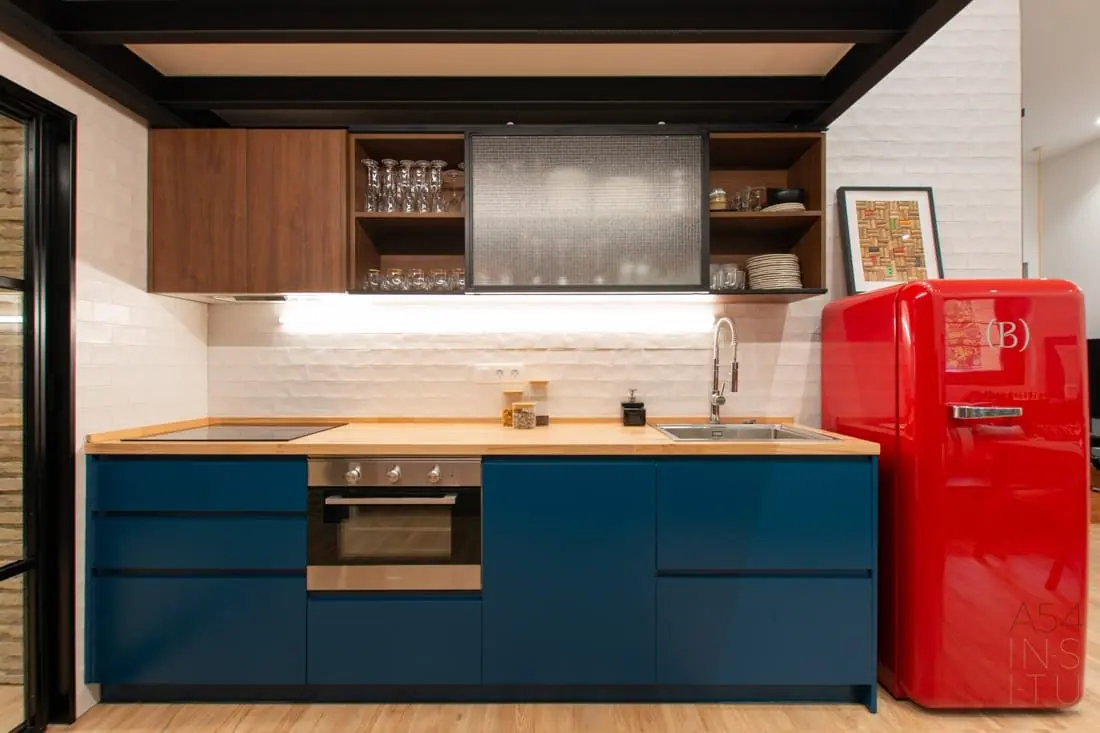 Cocina con muebles azules y nevera roja