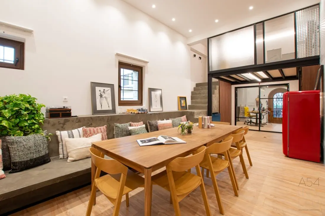 Sala con mesa larga de madera y escalera al fondo