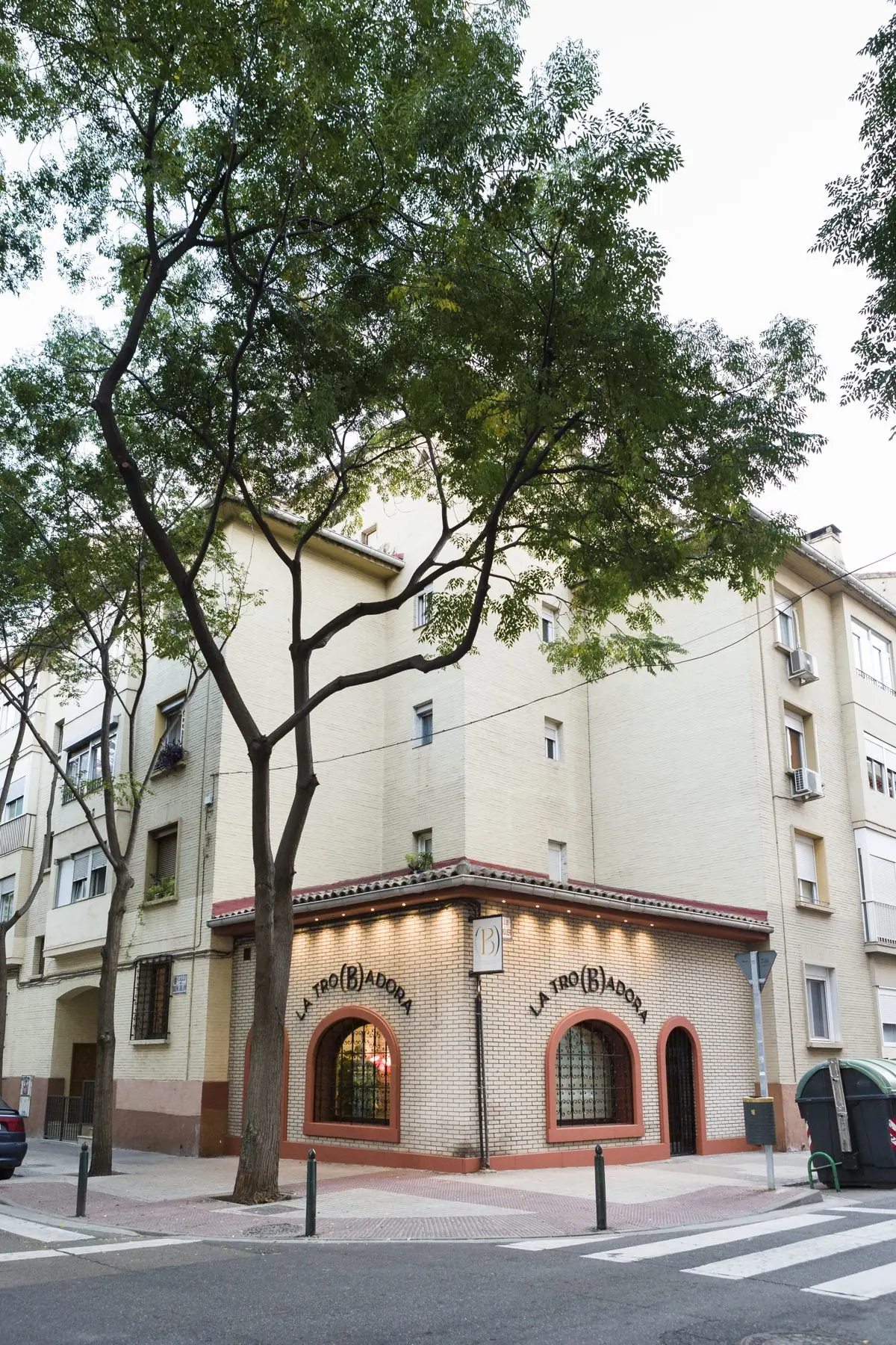 La esquina de La Tro(b)adora en la calle Bruno Solano, con un árbol delante